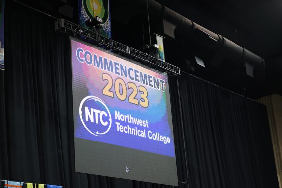 A sign on the screen in the Sanford Center welcomes attendees to NTC's commencement ceremony